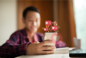 mobile phone with social media icons bursting from screen