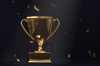 golden trophy on a black background with confetti