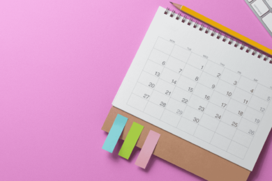 calendar on pink background with keyboard, mouse and sticky notes