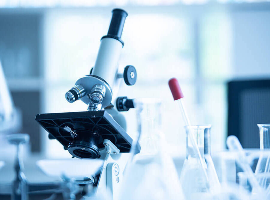 close up shot of a scientific microscope with blurred lab background